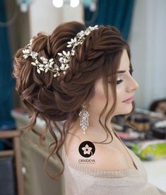 a woman with long brown hair wearing a tiara and pearls in her hair is looking off to the side