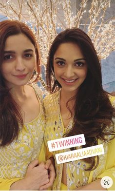 two women posing for the camera with one holding up a sticker that says winning