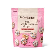 white fudge dipped mini cookies with sprinkles in a pink bag on a white background