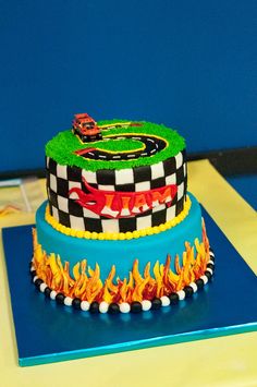 a birthday cake decorated with cars and flames