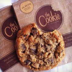 two cookies sitting next to each other on top of a brown paper bag with the logo of the cookie