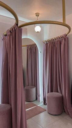 a room that has some curtains on the wall and two round stools in front of it