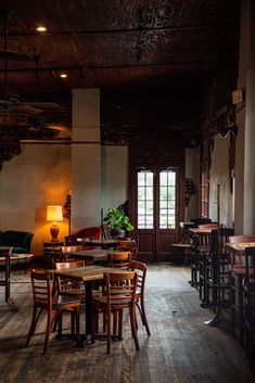 an empty restaurant with wooden tables and chairs