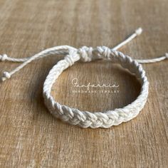 a white rope bracelet on top of a wooden table