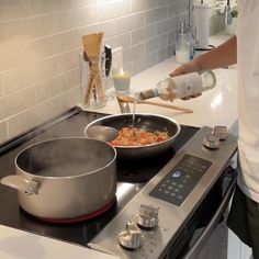 a person pouring something into a pan on the stove