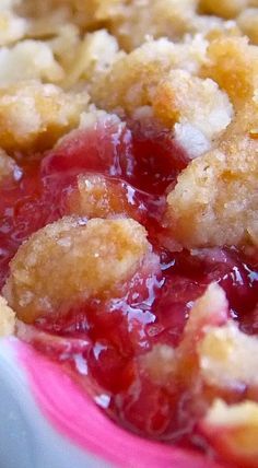 a close up of food in a bowl with crumbs and sauce on it