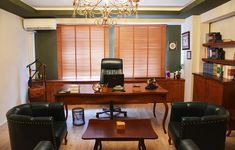 a living room filled with furniture and a chandelier hanging from the ceiling over a wooden table