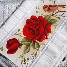 red roses and birds are on the white towel