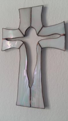 a cross made out of glass hanging on the wall