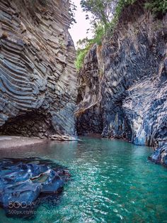 the water is crystal blue and green in this canyon area with rock formations on either side