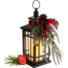 a lantern with christmas decorations on it and a red ornament next to it