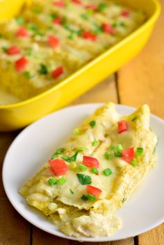 an omelet on a plate with a yellow casserole dish in the background