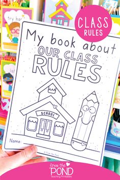 a hand holding up a book about rules in front of bookshelves with the title my book about our class rules