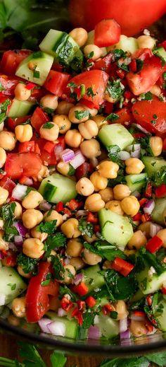 a salad with tomatoes, cucumbers, and chickpeas in a bowl