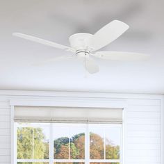 a white ceiling fan sitting above a window