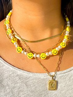 "🙂 Perfect Pearly Smiley Face necklace 🙂 Smiley faces are the new trend this summer. With a mix of white pearls and yellow smiley faces this necklace is here to stay. The \"Smile\" collection is meant to be for anyone who likes to have fun and be spontaneous! Materials: Beaded pearls and Smiley faces Electroplated Plastic Mix 14k gold plated lock and extensor Size: 18 inches or 45 cm Jewelry Care: *Allow perfumes and lotion to dry before wearing. *Remove before showering. *Remove when working Smiley Face Beaded Jewelry, Cheap Everyday Smiley Face Jewelry, Yellow Bead Necklace, Trendy Yellow Necklaces With Round Beads, Trendy Yellow Round Bead Necklaces, Trendy Yellow Round Beads Necklaces, Trendy Yellow Beaded Chain Necklace, Trendy Yellow Necklace With Beaded Chain, Trendy Everyday Pearl Necklace