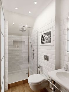 a bathroom with white tile walls and wooden floors