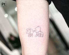 a small tattoo of two dogs on the arm