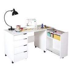 a sewing machine sitting on top of a desk next to a white cabinet with drawers