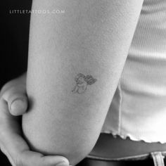 a small tattoo on the leg of a woman's arm, with an angel