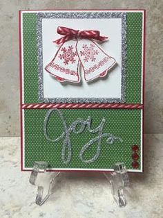 a christmas card with two bells on it, and the word joy written in silver