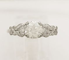 an antique style diamond engagement ring with filigrees