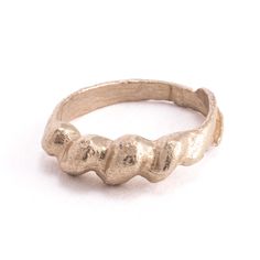 a silver ring with three small teeth on it's side, sitting on a white surface