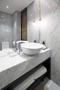 a bathroom with marble counter tops and white fixtures