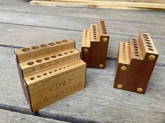 three wooden blocks with holes in them sitting on a table next to some wood planks