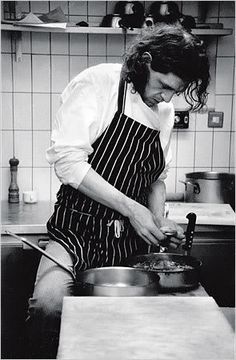 black and white photograph of a woman cooking in a kitchen