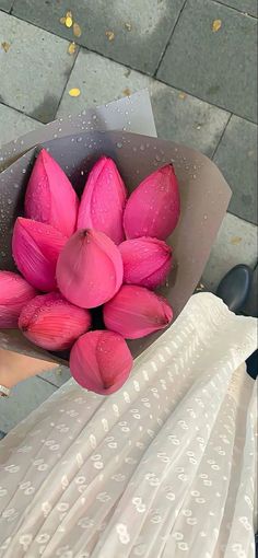 a woman holding a bouquet of pink flowers