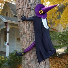 a scarecrow is climbing up the side of a tree