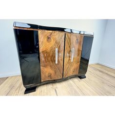 a black and brown cabinet sitting on top of a hard wood floor