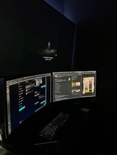 two computer monitors sitting next to each other on top of a black desk with keyboard and mouse