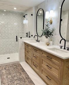 a large bathroom with two sinks and mirrors on the wall, along with a walk in shower