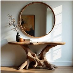 a wooden table with a mirror and vase on it