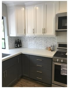 a kitchen with gray cabinets and white counter tops