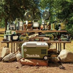 a table topped with lots of different types of items on top of grass covered ground