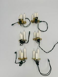 eight white candles are connected to black cords and plugged into the back of each other