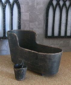 an old chair and bucket are sitting on the floor in front of some gothic windows