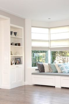 a window seat in the corner of a room with bookshelves on either side