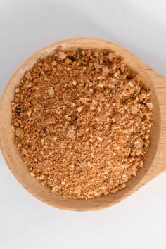 a wooden bowl filled with ground spices