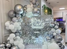 a silver and white party decoration with balloons