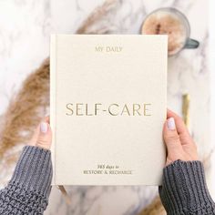 a person holding up a self care book