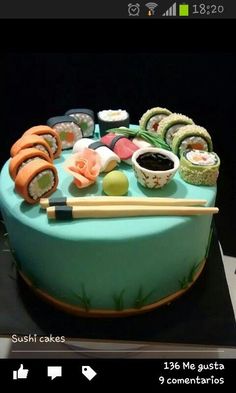 a cake with sushi cakes and chopsticks sitting on it's side