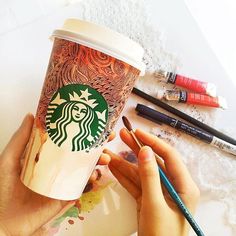 someone is painting a cup of starbucks coffee