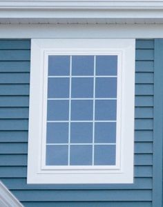 a red stop sign sitting in front of a blue house with white trim on it