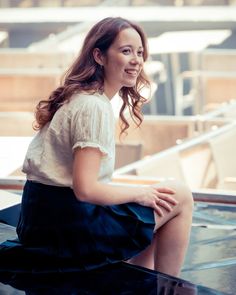 a woman sitting on top of a glass table