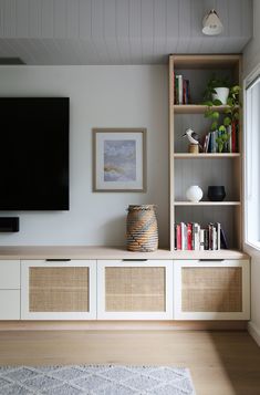 an entertainment center with bookshelves and a flat screen tv mounted on the wall