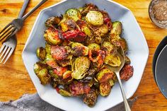 a white plate topped with brussel sprouts and bacon